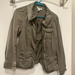 Olive green zip up jacket with lots of buttons zippers and pockets